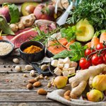 a collection of healthy foods arranged on a wooden table