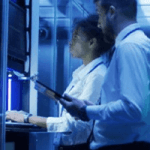 two people check on a server